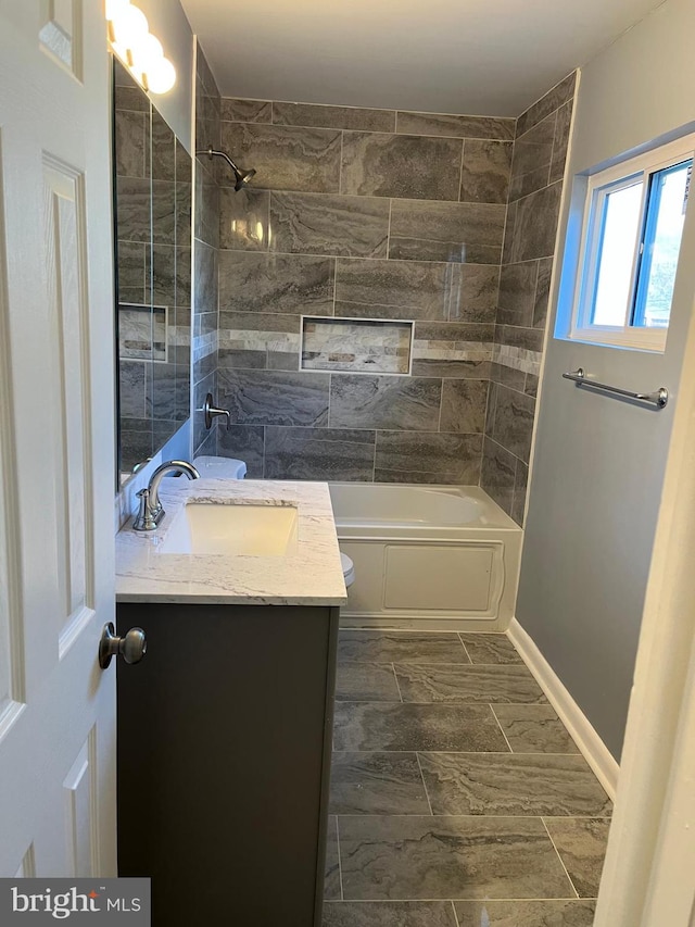 full bathroom with toilet, vanity, and tiled shower / bath