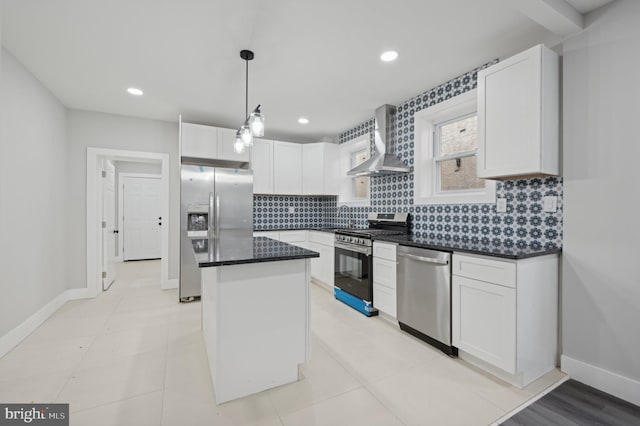 kitchen with wall chimney exhaust hood, stainless steel appliances, pendant lighting, a center island, and white cabinetry