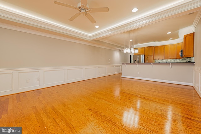 unfurnished living room with light wood-type flooring, ceiling fan, and ornamental molding