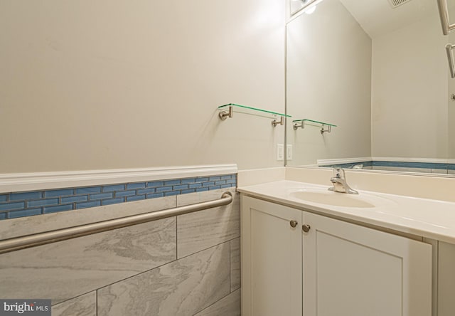 bathroom with vanity and tile walls