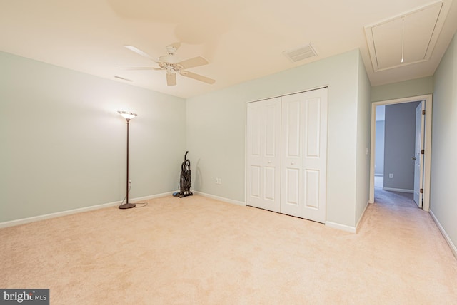 unfurnished bedroom with ceiling fan, light carpet, and a closet