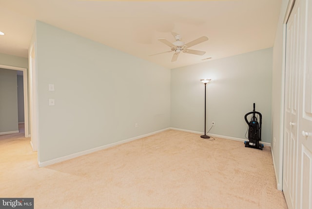 carpeted spare room featuring ceiling fan