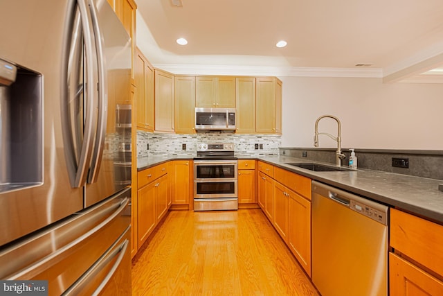 kitchen with decorative backsplash, appliances with stainless steel finishes, light wood-type flooring, crown molding, and sink