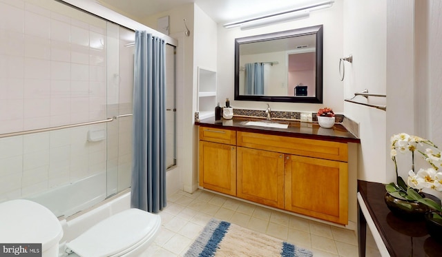 full bathroom with tile patterned floors, vanity, toilet, and bath / shower combo with glass door