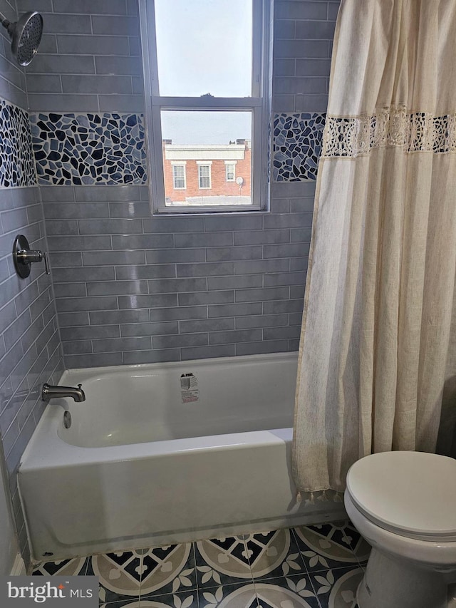 bathroom with tile patterned floors, shower / bath combination with curtain, and toilet