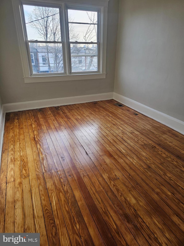 empty room featuring a wealth of natural light and hardwood / wood-style floors