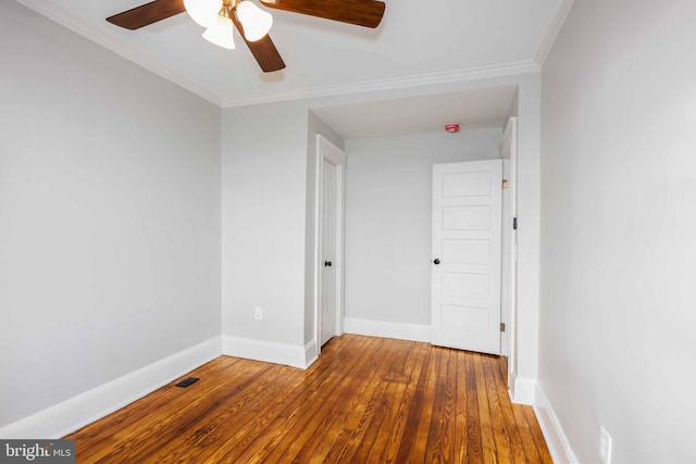 empty room with ceiling fan, hardwood / wood-style floors, and ornamental molding