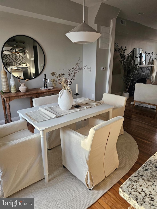 dining room with a fireplace and hardwood / wood-style flooring