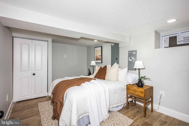 bedroom with dark hardwood / wood-style flooring and a closet