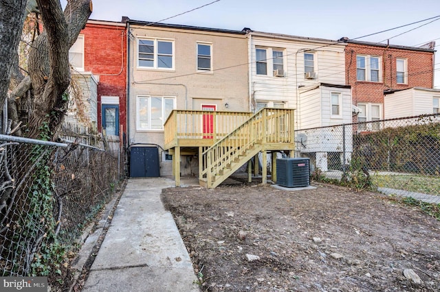 rear view of property with central AC unit and a deck