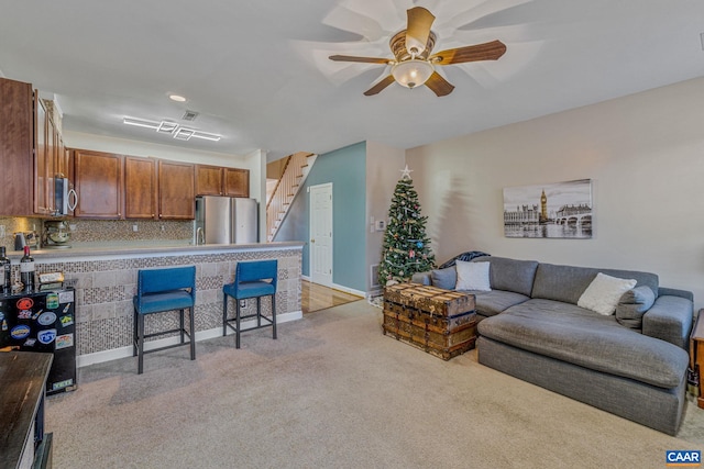 living room featuring light colored carpet and ceiling fan