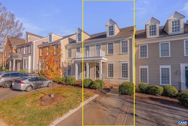 view of front of property featuring a balcony and a front lawn