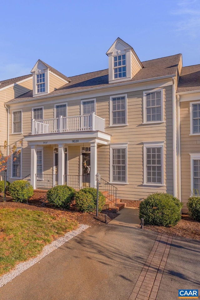 view of property with a porch and a balcony