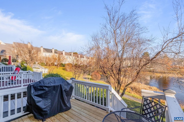 deck with a water view and area for grilling