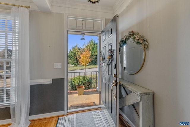 foyer entrance with wood-type flooring and ornamental molding