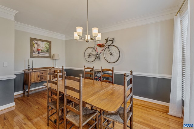 dining area featuring hardwood / wood-style floors, a notable chandelier, and crown molding