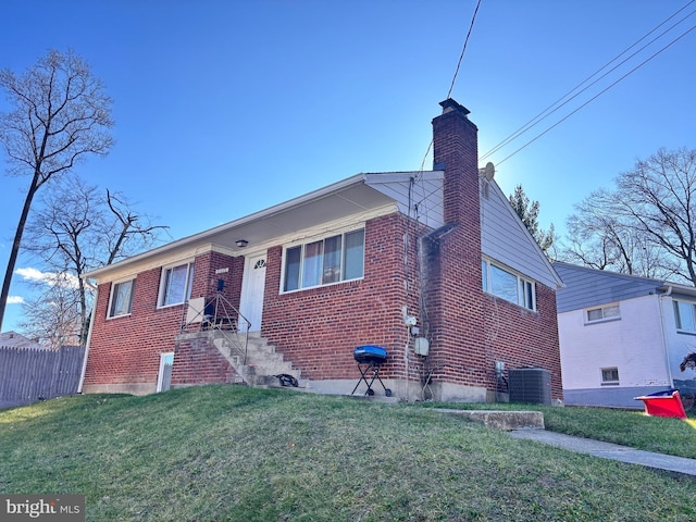 bungalow with fence, a front yard, brick siding, central AC unit, and a chimney