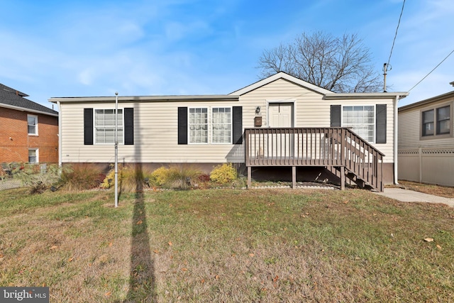 view of front facade with a front yard and a wooden deck