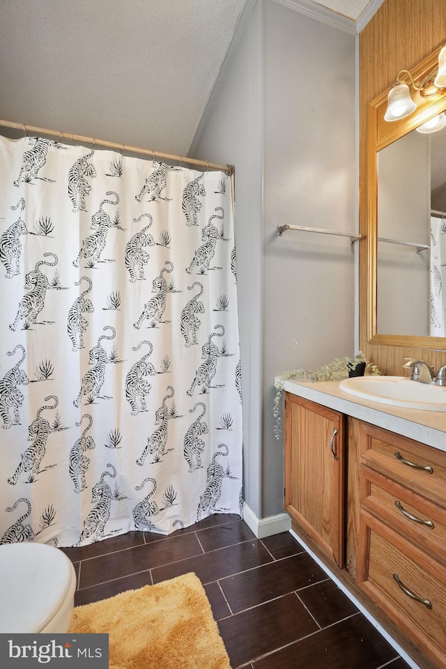 bathroom featuring a shower with shower curtain, vanity, toilet, and crown molding