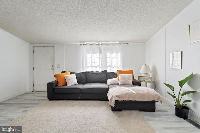 living room featuring light hardwood / wood-style floors and a textured ceiling