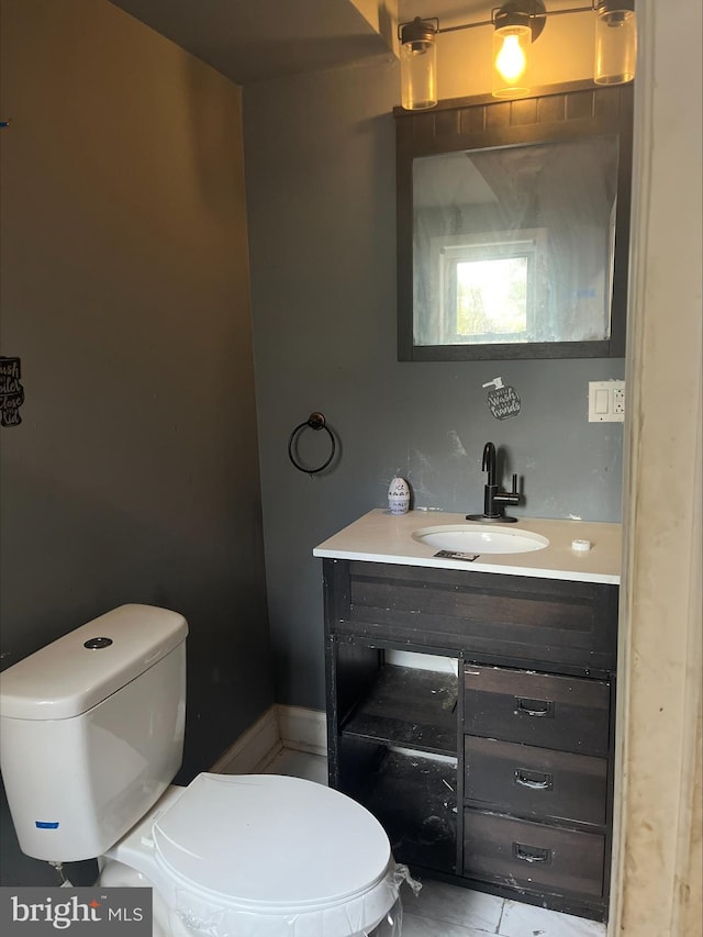 bathroom with tile patterned flooring, vanity, and toilet