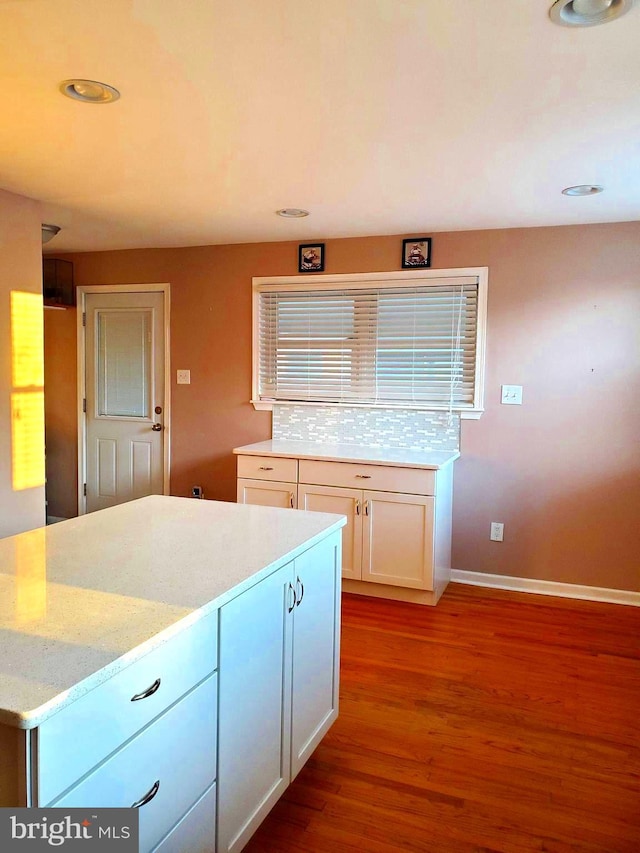 451 Ridge Pike, Lafayette Hill, PA 19444 - kitchen featuring wood finished floors, light stone countertops, baseboards, white cabinetry, and tasteful backsplash