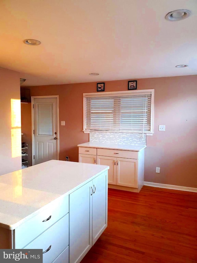 451 Ridge Pike, Lafayette Hill, PA 19444 - kitchen with wood finished floors, white cabinetry, light stone counters, baseboards, and decorative backsplash