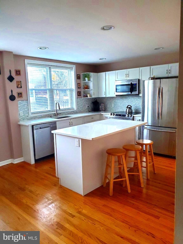 451 Ridge Pike, Lafayette Hill, PA 19444 - kitchen featuring stainless steel appliances, a sink, a kitchen island, tasteful backsplash, and light wood-type flooring
