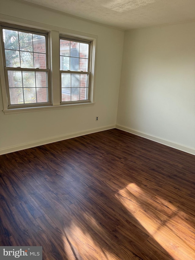 unfurnished room featuring a textured ceiling and dark wood-type flooring