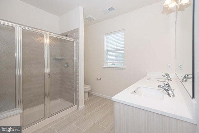 bathroom with vanity, toilet, and a shower with shower door