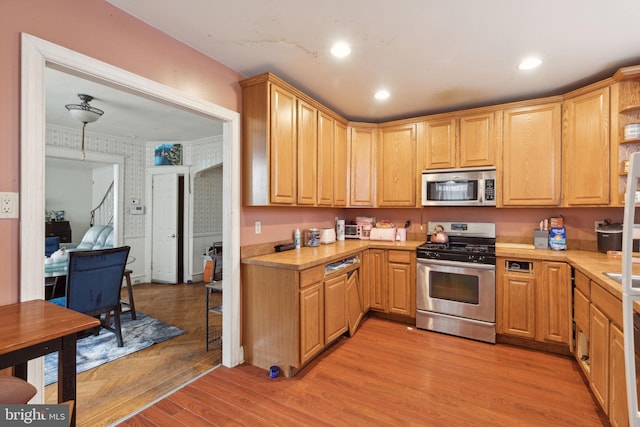 kitchen featuring light wood-type flooring and appliances with stainless steel finishes