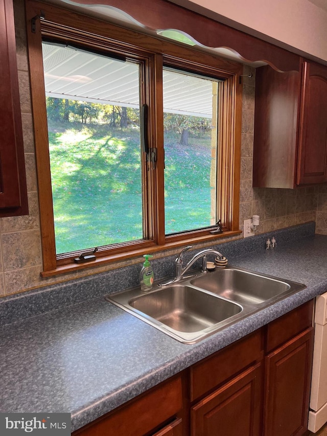 kitchen featuring backsplash, plenty of natural light, and sink