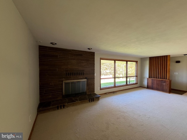 unfurnished living room featuring a large fireplace and carpet floors