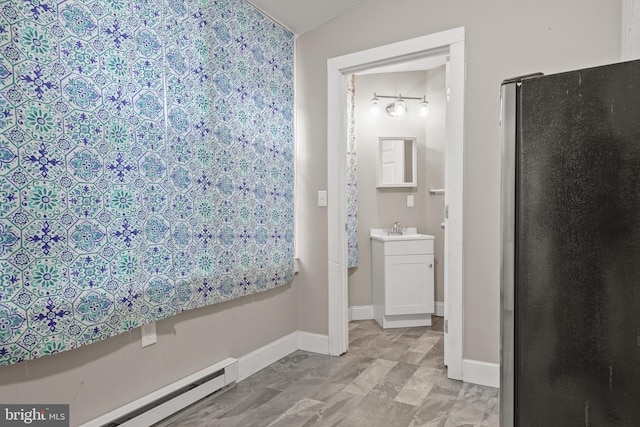 bathroom with vanity, baseboard heating, and vaulted ceiling