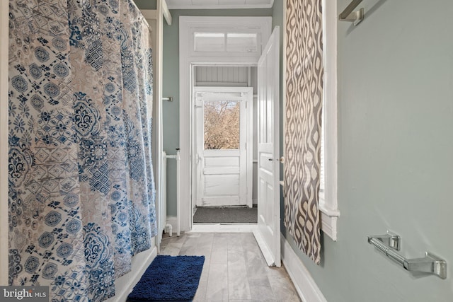 bathroom featuring ornamental molding and walk in shower