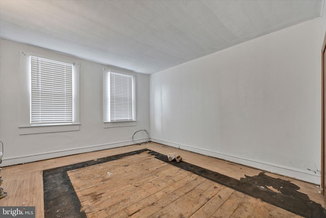 spare room featuring wood-type flooring and baseboard heating