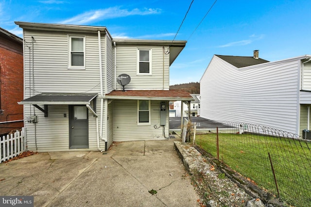 rear view of house featuring a yard and a patio