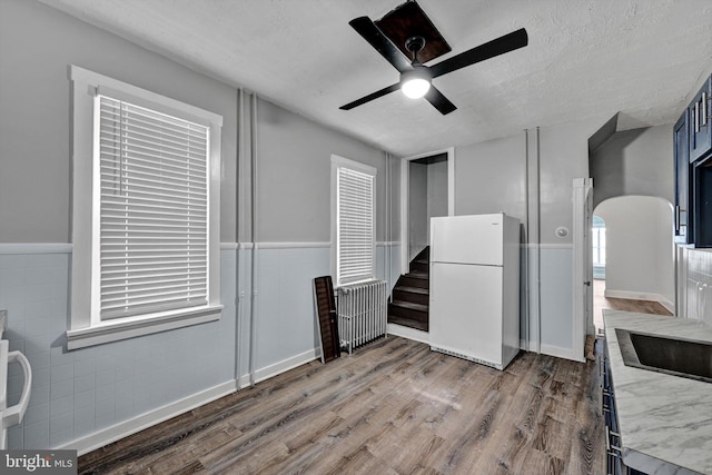 kitchen with a textured ceiling, white fridge, hardwood / wood-style flooring, and ceiling fan