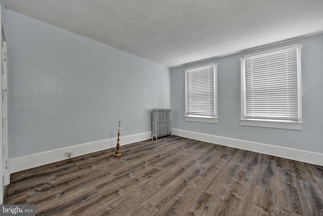 unfurnished room featuring radiator heating unit and dark wood-type flooring