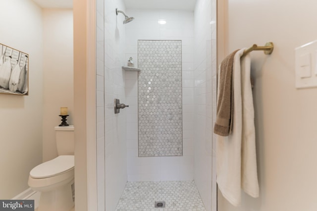 bathroom featuring toilet and a tile shower