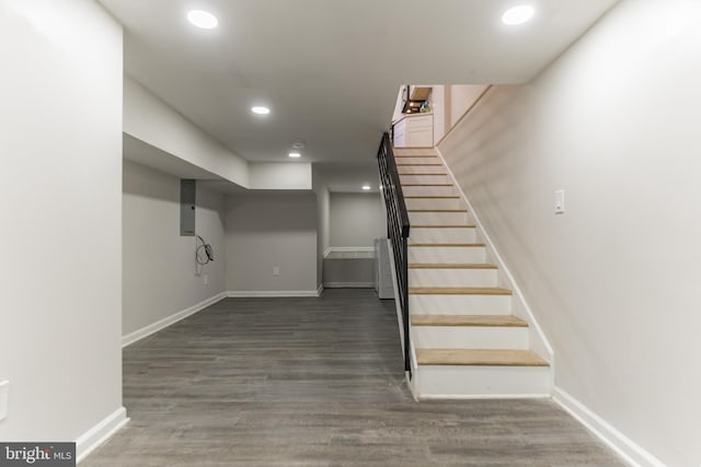 staircase featuring hardwood / wood-style flooring and electric panel