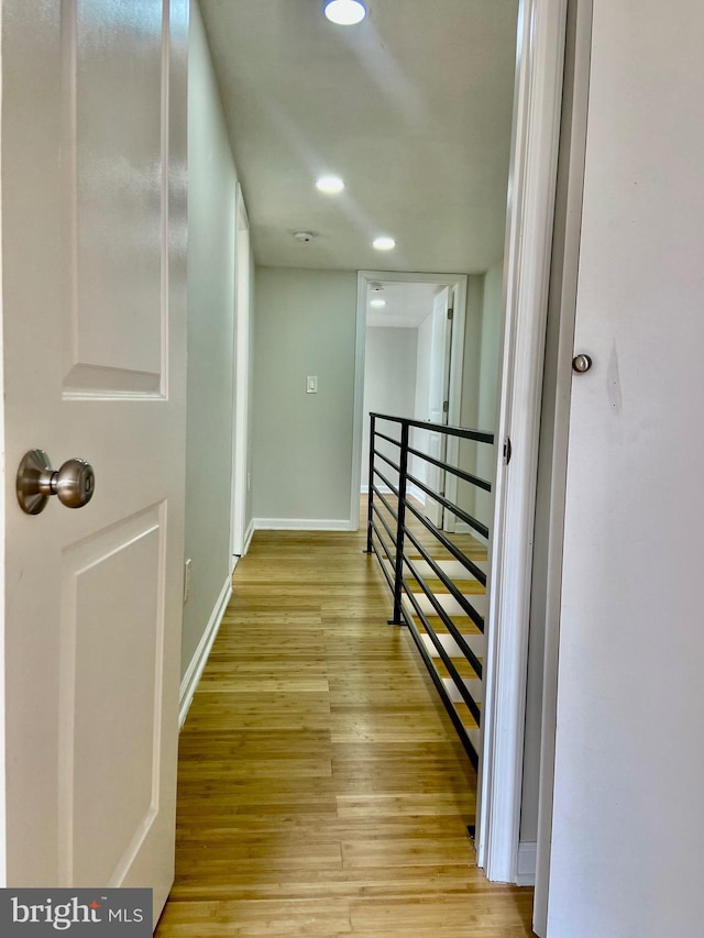 hallway with light hardwood / wood-style floors