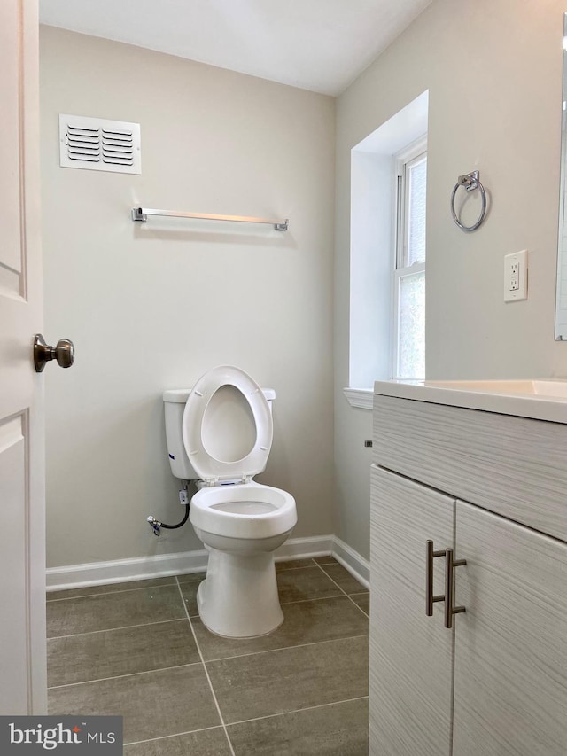 bathroom featuring tile patterned flooring, vanity, and toilet