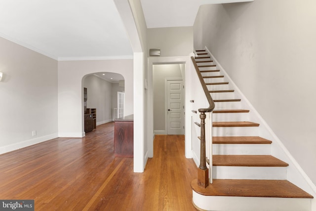 staircase featuring hardwood / wood-style flooring and ornamental molding