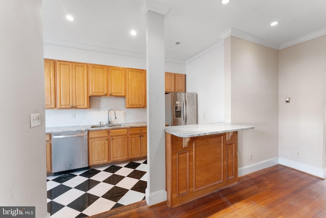 kitchen with appliances with stainless steel finishes, crown molding, a breakfast bar area, and sink