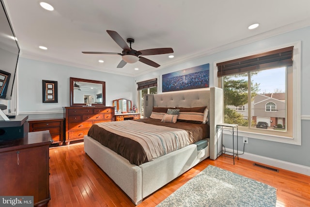 bedroom featuring ceiling fan, wood-type flooring, and ornamental molding