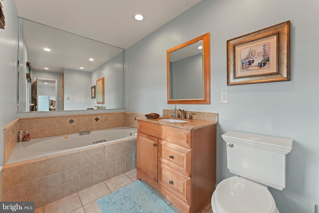 bathroom with toilet, vanity, tile patterned floors, and tiled tub