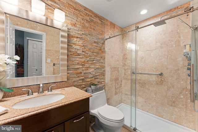 bathroom with vanity, toilet, and a shower with shower door