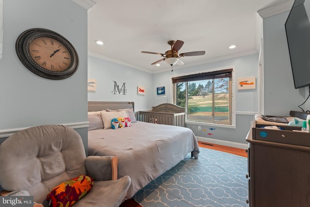 bedroom featuring light hardwood / wood-style flooring, ceiling fan, and crown molding