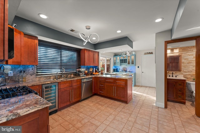 kitchen featuring backsplash, stainless steel dishwasher, beverage cooler, sink, and decorative light fixtures